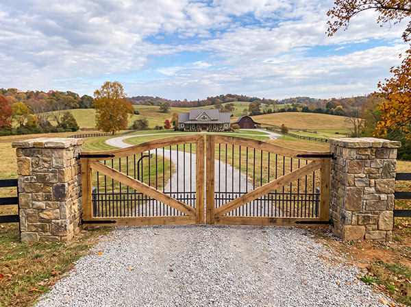 Custom double driveway gate at a rural property entrance